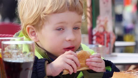 Young Blond Boy (3-4 Years Old) Eating Sandwich In Cafe alt
