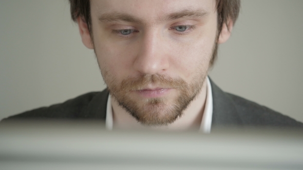 Male Businessman Looking At Computer Screen In Office