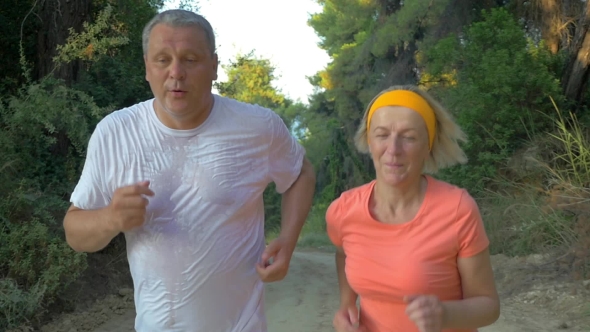 Senior Couple Jogging In The Forest alt