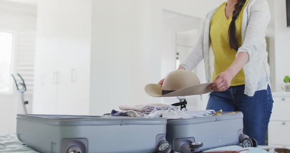 Happy asian woman preparing clothes and suitcase for travel