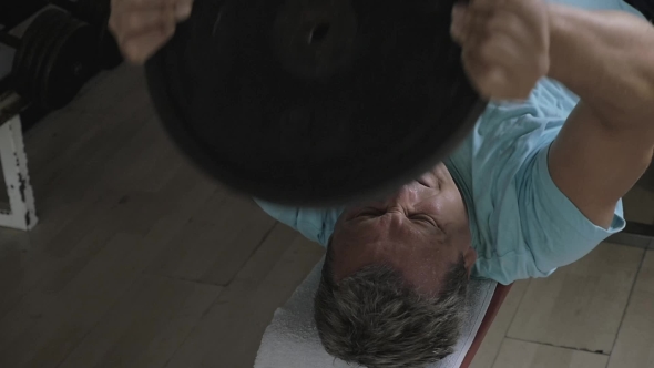 Senior Man Exercising With Disk Weight