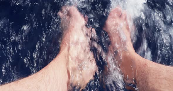 Bare Feet are Lowered From the Boat in Water in Sunny Day Feet of the Adult Man Blue Water Splashes