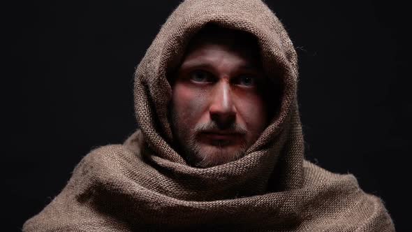 Homeless Man With Bruised Face Looking Into Camera Isolated on Black Background