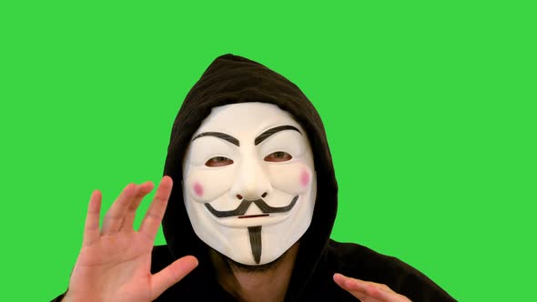 Man Wearing Vendetta Mask Talking on Camera on a Green Screen Chroma Key