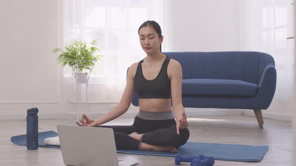 Asian woman does morning yoga, sitting in Easy position, Sukhasana posture,