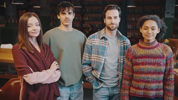 Portrait of Diverse Multicultural Smiling Young Persons Coworkers in Library