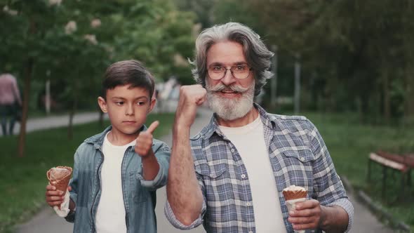 Young Boy and Granfather Holding Ice-creams Outdoors