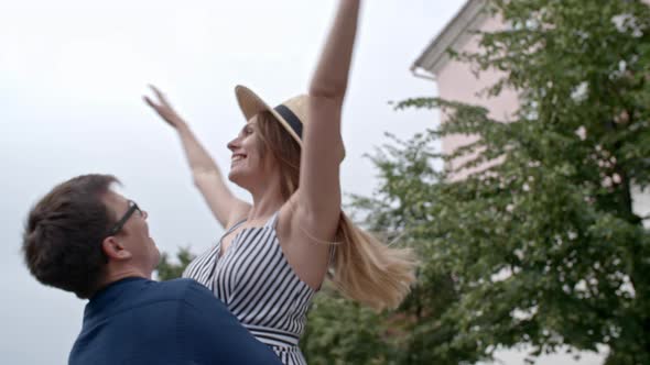 Man Spinning Around His Girlfriend Outdoors