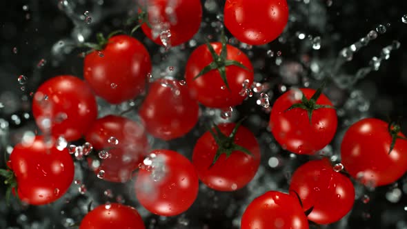 Super Slow Motion Shot of Flying Cherry Tomatoes with Water Towards the Camera at 1000Fps