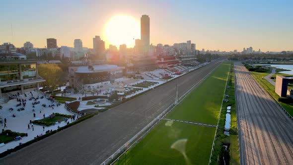 Sun sets over Hipodromo Argentino de Palermo horse racing track, spectators gathering