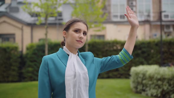 Brunette Young Caucasian Woman with Brown Eyes Looking Away and Raising Hand. Portrait of Elegant