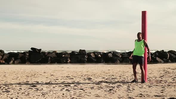 Man taking a break from running on the beach