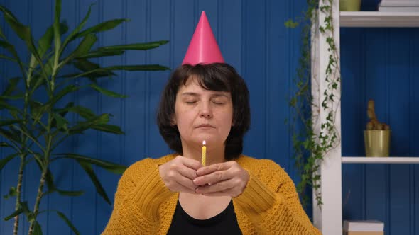Middle Aged Woman in Hat Celebrating Birthday Alone