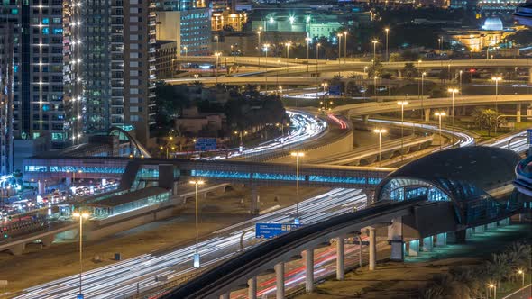 Futuristic Building of Dubai Metro and Tram Station and Luxury Skyscrapers Behind Night Timelapse