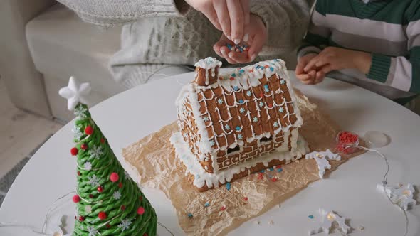 Little Boy with Mother Decorating Christmas Gingerbread House Together Family Activities and