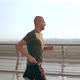 Young Man in Sports Uniform Runs on the Pedestrian Bridge at Dawn - VideoHive Item for Sale