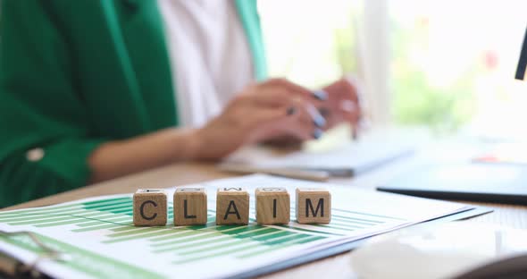 Businesswoman Typing on Keyboard Against Background of Wooden Cubes with Word Claim  Movie