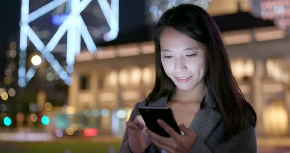 Businesswoman use of smart phone in city at night