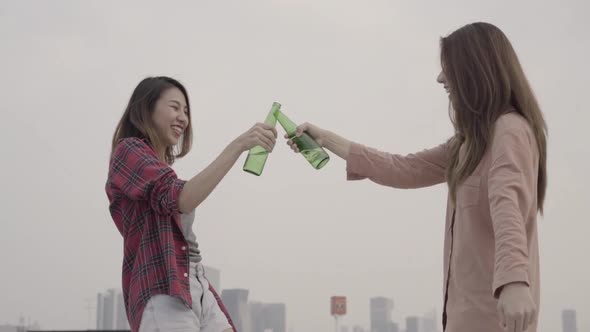 Group young asian women people dancing and raising their arms up on rooftop.