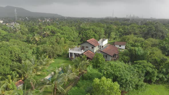 Circular drone shot of large holiday home with swimming pool Indian countryside