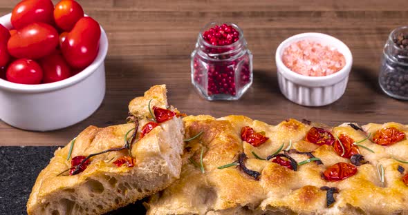 Homemade italian flat bread - Focaccia contorta. With olives, olive oil, rosemary, tomatoes. Traditi