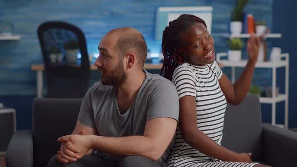 Irritated Interracial Couple Fighting and Sitting on Couch