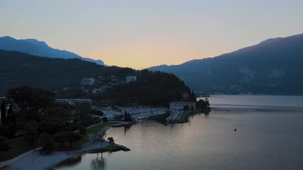 Aerial view of Riva del Garda. Overview of the city at sunrise with Garda lake on background. Shooti