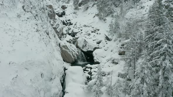 Aerial dolly of small waterfalls in snowcovered wilderness