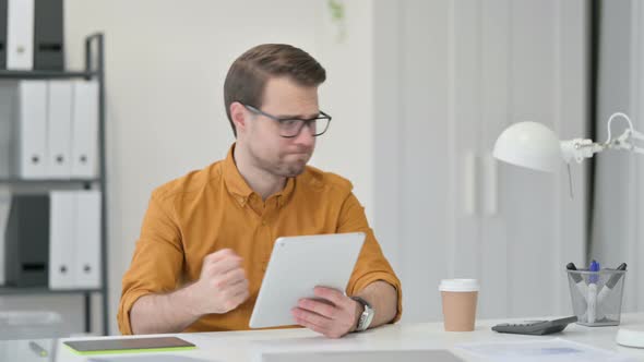 Young Man Reacting To Loss on Tablet 