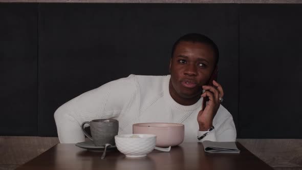 Black Guy Talking on the Phone in a Cafe