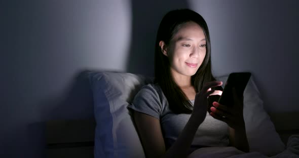 Woman use of cellphone on bed