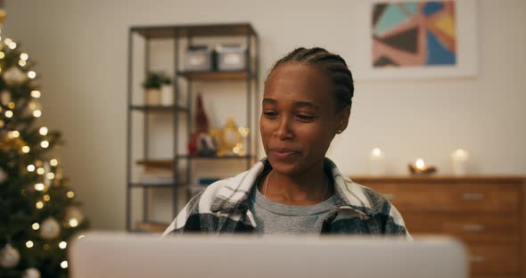 An Africanlooking Woman Sits at Table in the Living Room and Has Video Chat with Colleagues alt