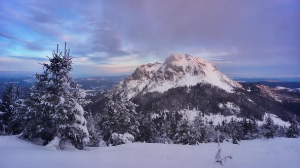 Winter Sunrise Over Snowy Mountains Clouds Spill Over the Mountain Windy Weather