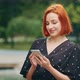 Pretty Caucasian Lady Girl Stand Outdoors in City Park Look at Mobile Phone Use Urban Wifi Beautiful - VideoHive Item for Sale