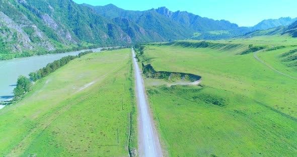 Aerial Rural Mountain Road and Meadow at Sunny Summer Morning