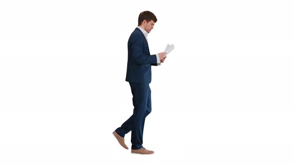 Concentrated Businessman Reading Documents or Report While Walking on White Background