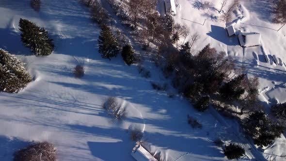 Aerial Shot Detail of a Small Village Among Trees Winter Wooded Mountain Landscape