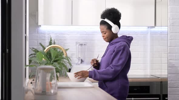 African American Black Handsome Woman Cooking Dancing with Headphones Enjoy Life Listening Favourite