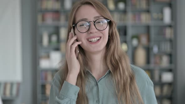 Portrait of  Young Woman Talking on Smartphone in Office