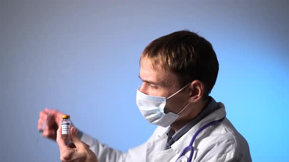 Male Doctor Drawing Up COVID19 Vaccine From Vial