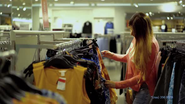 Girl Chooses Clothes in Supermarket