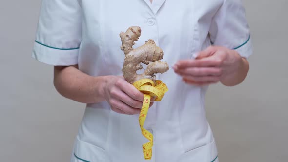 Nutritionist Doctor Healthy Lifestyle Concept - Holding Ginger Root and Measuring Tape