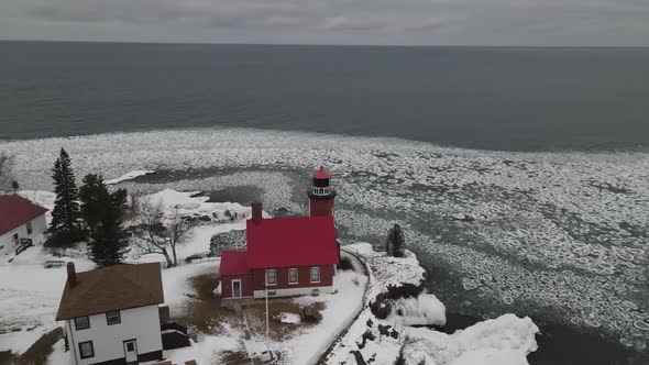 Eagle Harbor, Michigan lighthouse in winter along Lake Superior. 4k drone video.