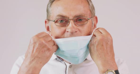 An Elderly Man Puts on His Medical Mask During a Pandemic