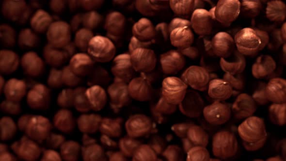 Super Slow Motion Shot of Hazelnuts Flies After Being Exploded Against Black Background, 1000Fps.