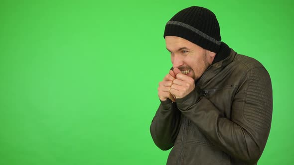 A Young Handsome Man in a Winter Outfit Trembles in Cold Weather - Green Screen Studio