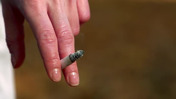 Slowmotion Detail of Woman´s Finger Which Holds a Cigarette