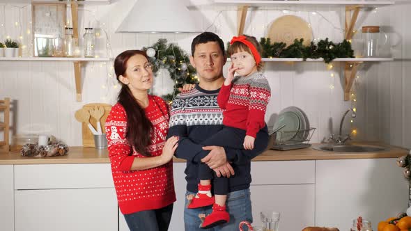 Family Poses at Photoshoot Against Yellow Garland in Kitchen