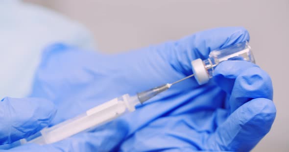 Extreme Close Up of Hand Holding Syringe and Vaccine in Hand in Laboratory.