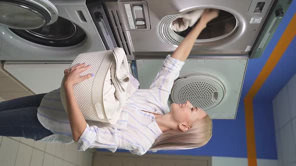 Smiling Attractive Woman in a Public Laundry Room